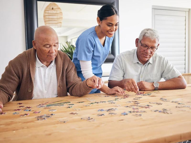 seniors and caretaker doing a puzzle